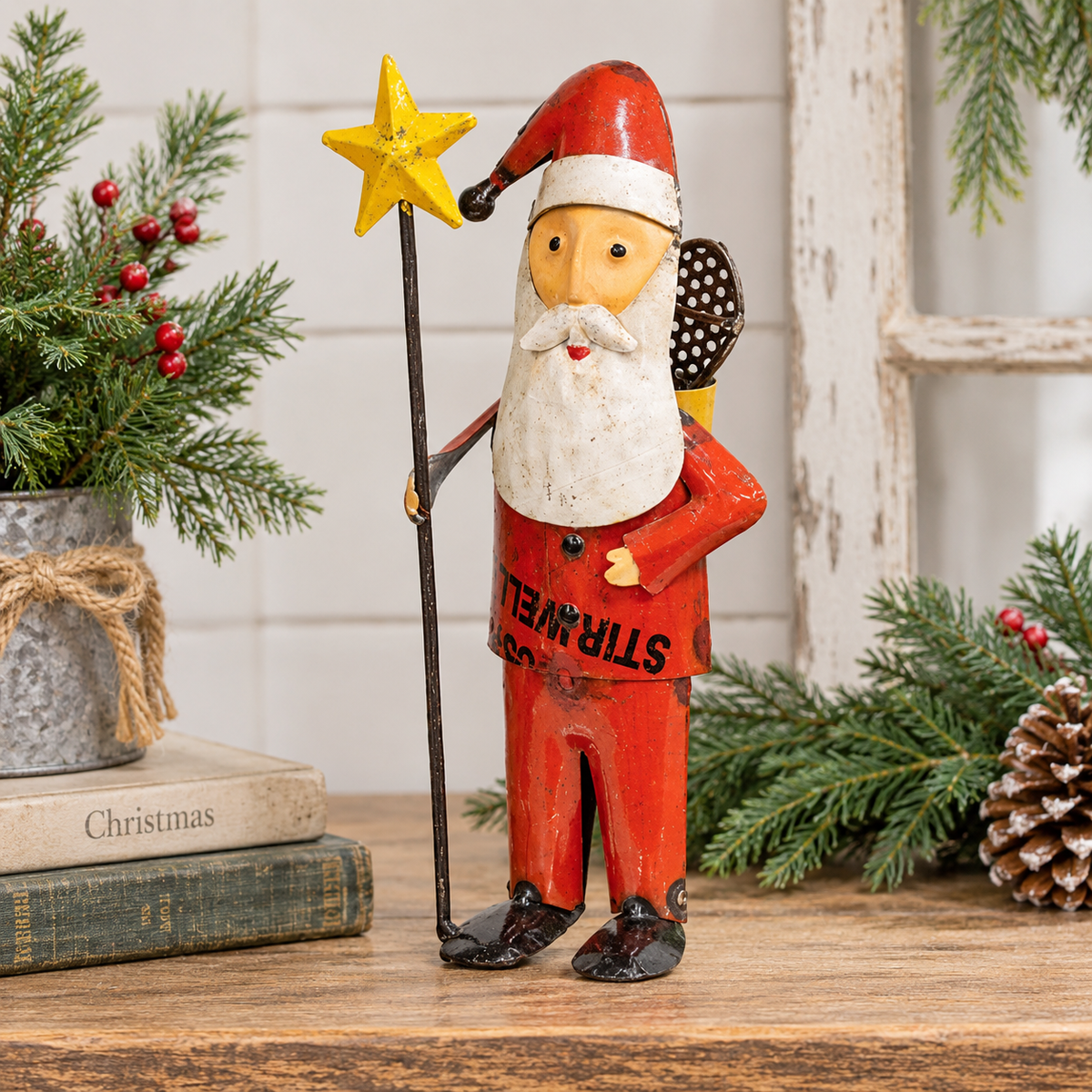 A rustic Santa Claus figurine standing on a wooden surface, holding a yellow star staff. The figurine has a weathered red coat with 'STEAMWHEELS' printed on the front, a white beard, and a red hat.