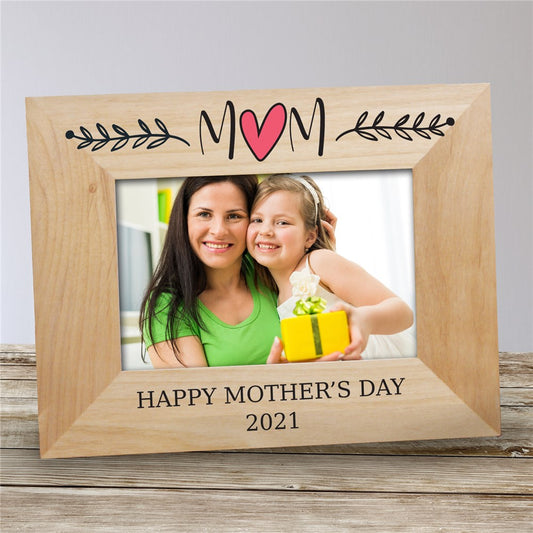 Personalized wooden picture frame engraved with “Mom” and a heart, featuring a photo slot and space for a custom message and year.