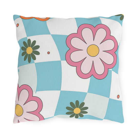 Square floral outdoor pillow with blue, orange, pink, and green design on garden bench