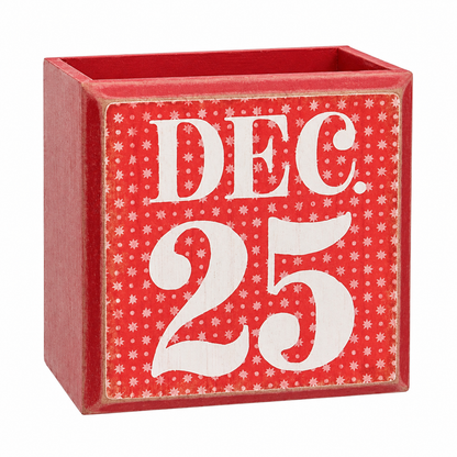 A square red wooden decorative box with an open top, featuring a front panel printed with 'DEC. 25' in large white letters over a red background with small white star-like motifs.