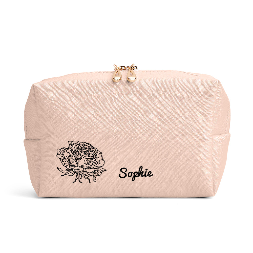 A close-up view of the beige makeup bag, displaying the personalized birth flower and name detail.