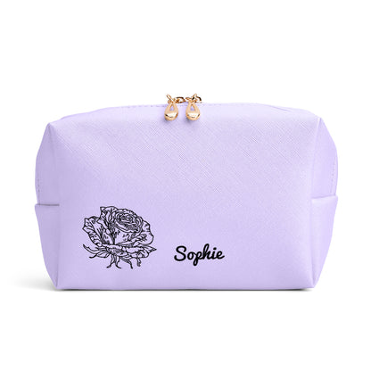 A close-up view of the purple makeup bag, highlighting the delicate personalized design with a birth flower and name.