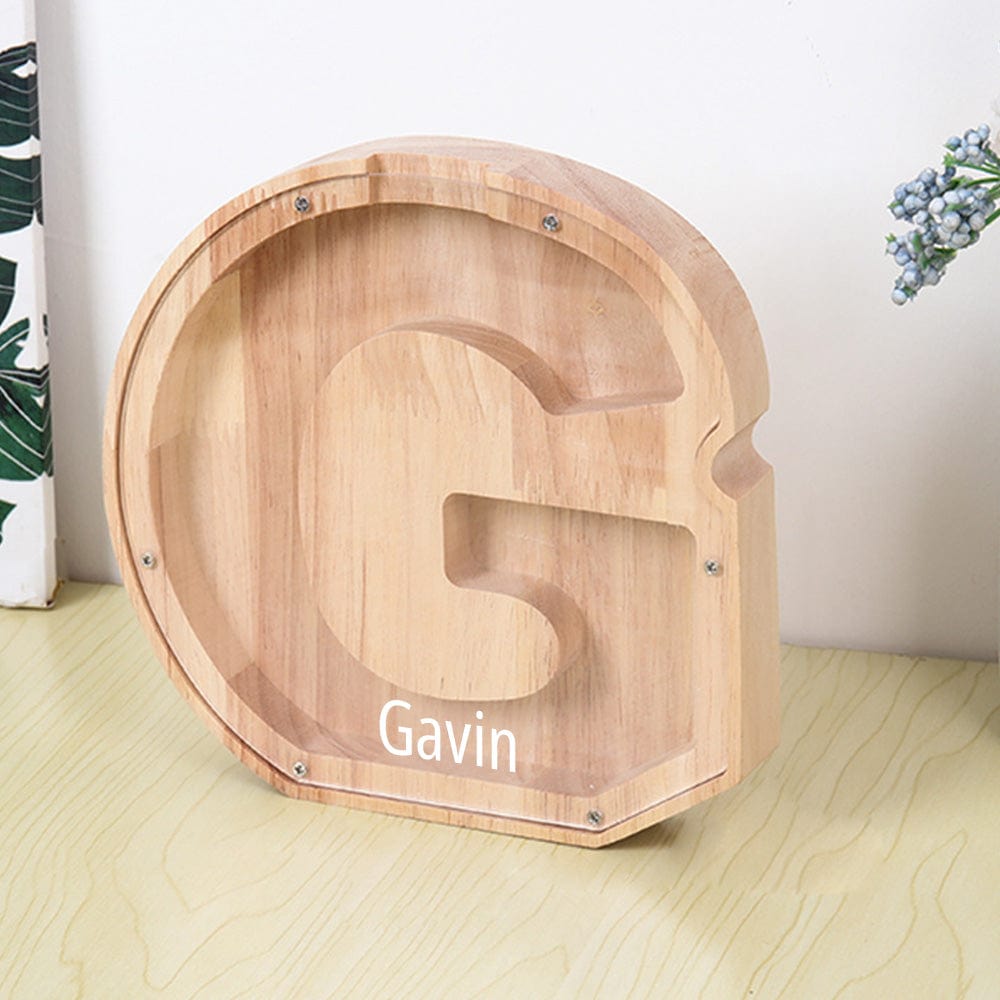 A personalized "G" piggy bank in burlywood, designed with an acrylic surface to watch coins collect.