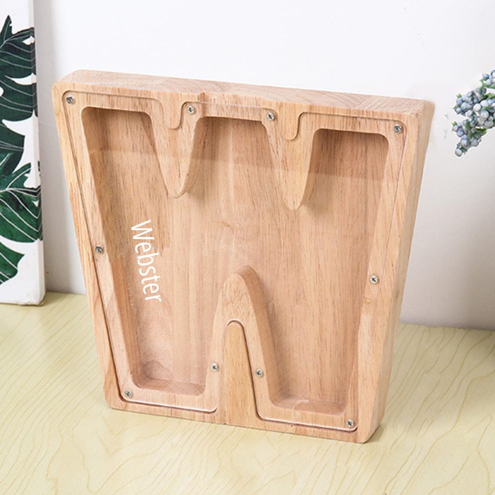 A personalized "W" piggy bank in burlywood, combining a wooden base and acrylic panel for monitoring savings.