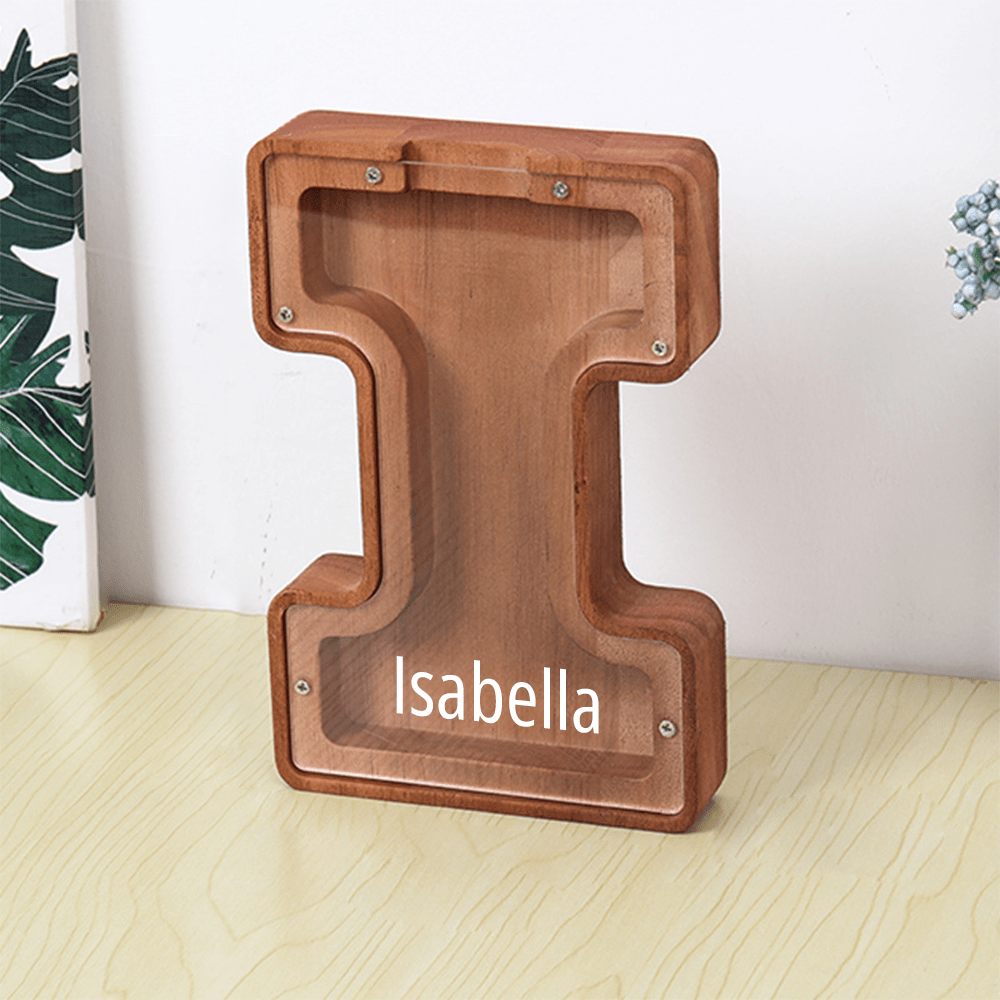 A wooden "I" piggy bank in brown, featuring a clear acrylic panel for kids to observe their coin collection.