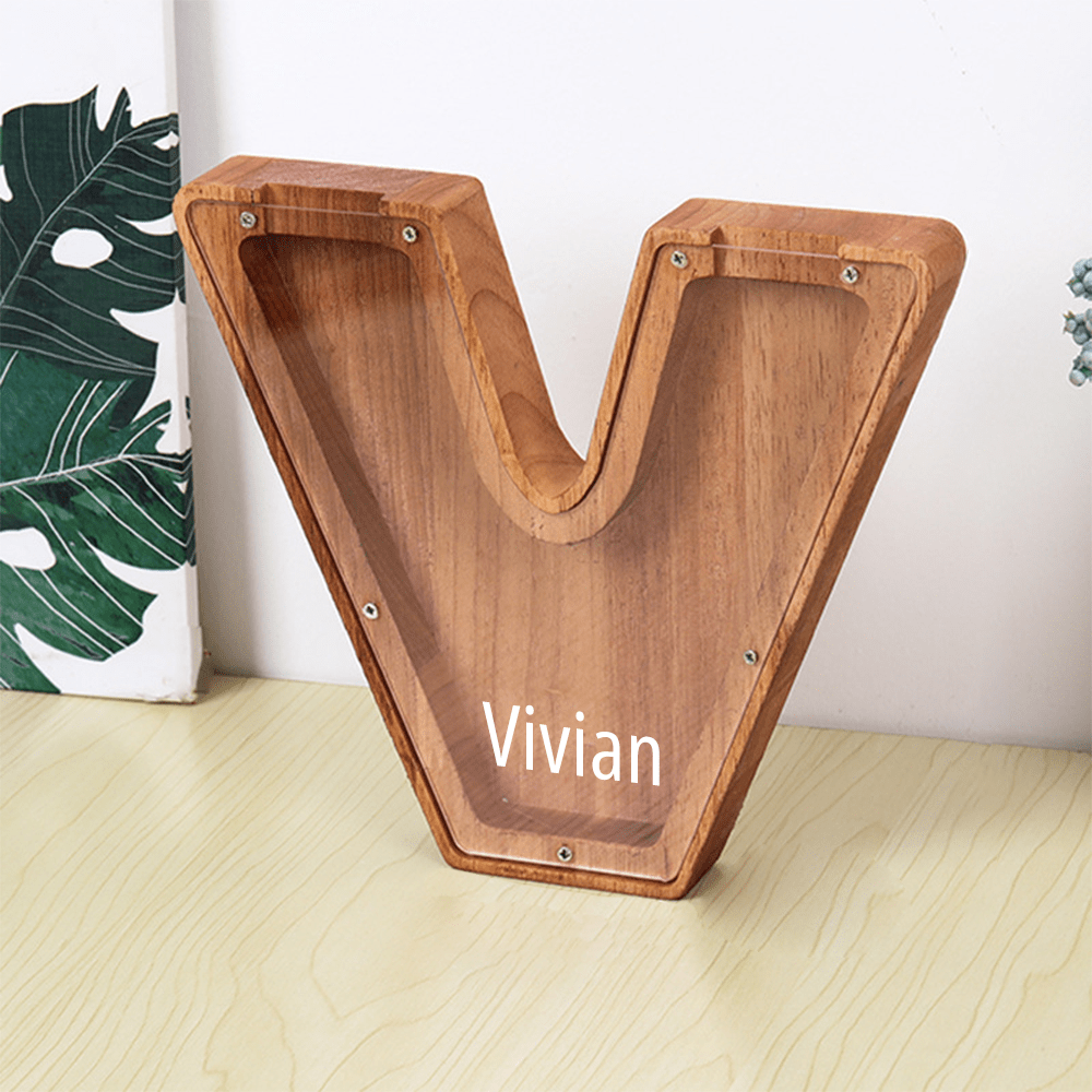 A "V" letter piggy bank in brown with a transparent acrylic surface, ideal for children to visually track their money savings.