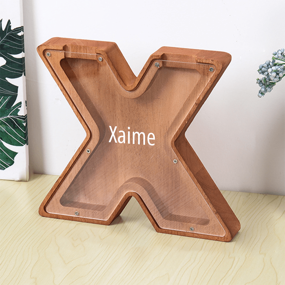 A "X" letter piggy bank in dark brown, with a clear acrylic front to help children keep track of their savings in an engaging way.