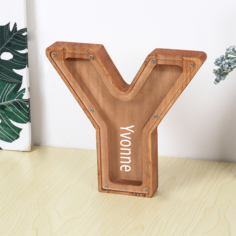 A "Y" shaped piggy bank made of brown wood, complete with an acrylic front for children to watch their savings accumulate.