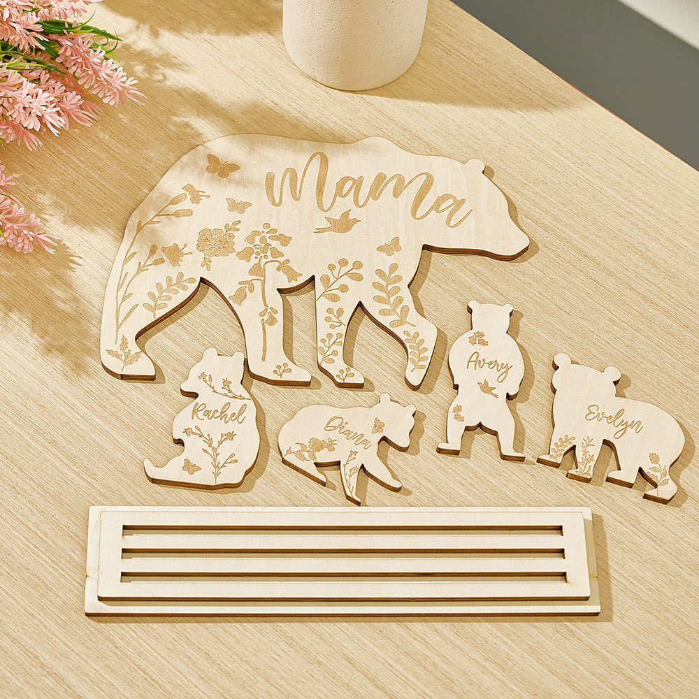 A wooden table decoration featuring a mama bear and four cubs, each customizable with the customer's choice of text, laid flat on the table to show how the pieces (mama bear and cubs) separate from their stand.