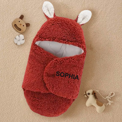 Personalized red swaddle blanket with custom name, designed for warmth and style, perfect for outdoor outings and keeping your baby snug.