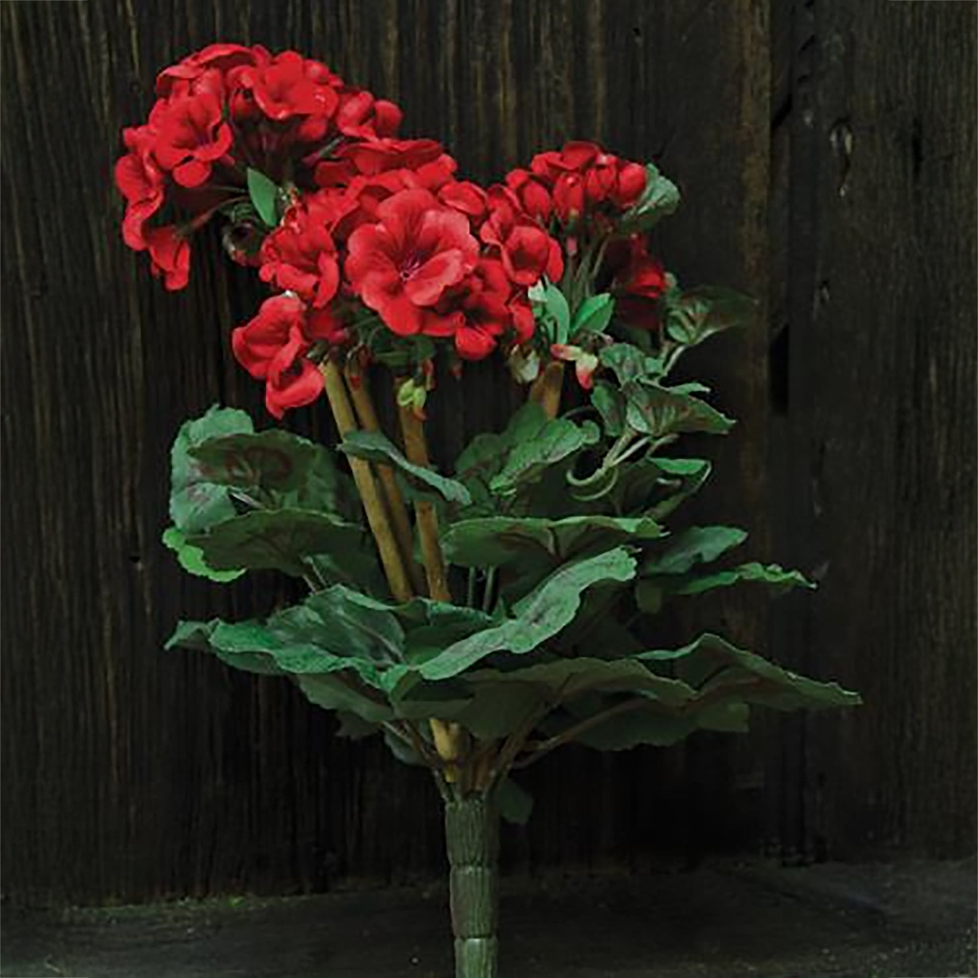 Bright red faux geranium bush with natural greenery for spring and summer decorating