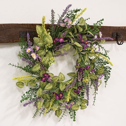 Spring wreath with purple blooms, lavender buds, and green textured foliage