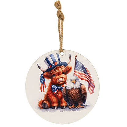 Rustic Americana Highland cow ornament with patriotic red white and blue artwork on round wooden hanging décor
