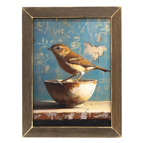 Rustic framed print with bird on bowl, floral wallpaper background, and distressed wood frame.