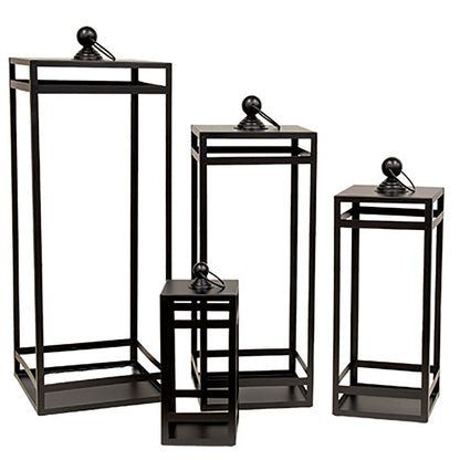 Black geometric metal lantern set with open frame design and swing handles styled for rustic home decorating