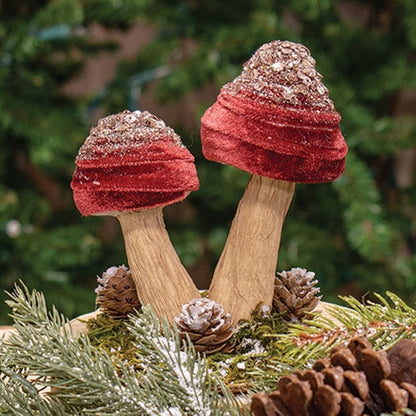 Burgundy velvet mushroom sitter with gold glitter accents and pinecone details