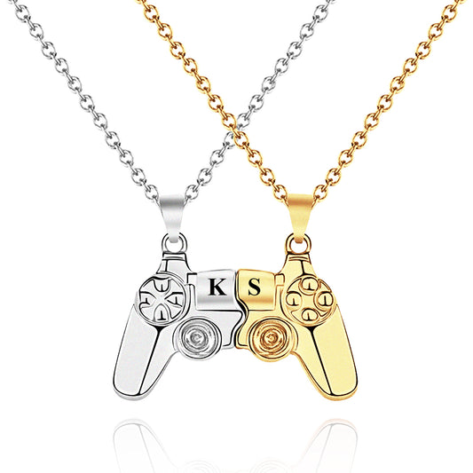 Close-up of a magnetic gamer couple necklace featuring two video game controller halves with engraved initials, symbolizing connection and love.