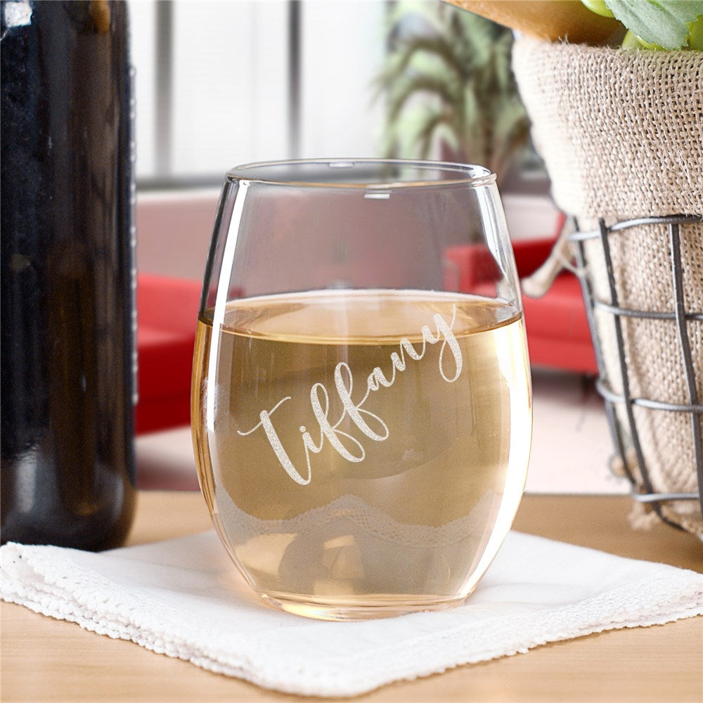 Personalized stemless wine glass engraved elegantly with custom script name, perfect for weddings, anniversaries, and personalized gift-giving. Clear glass holds 17 ounces.