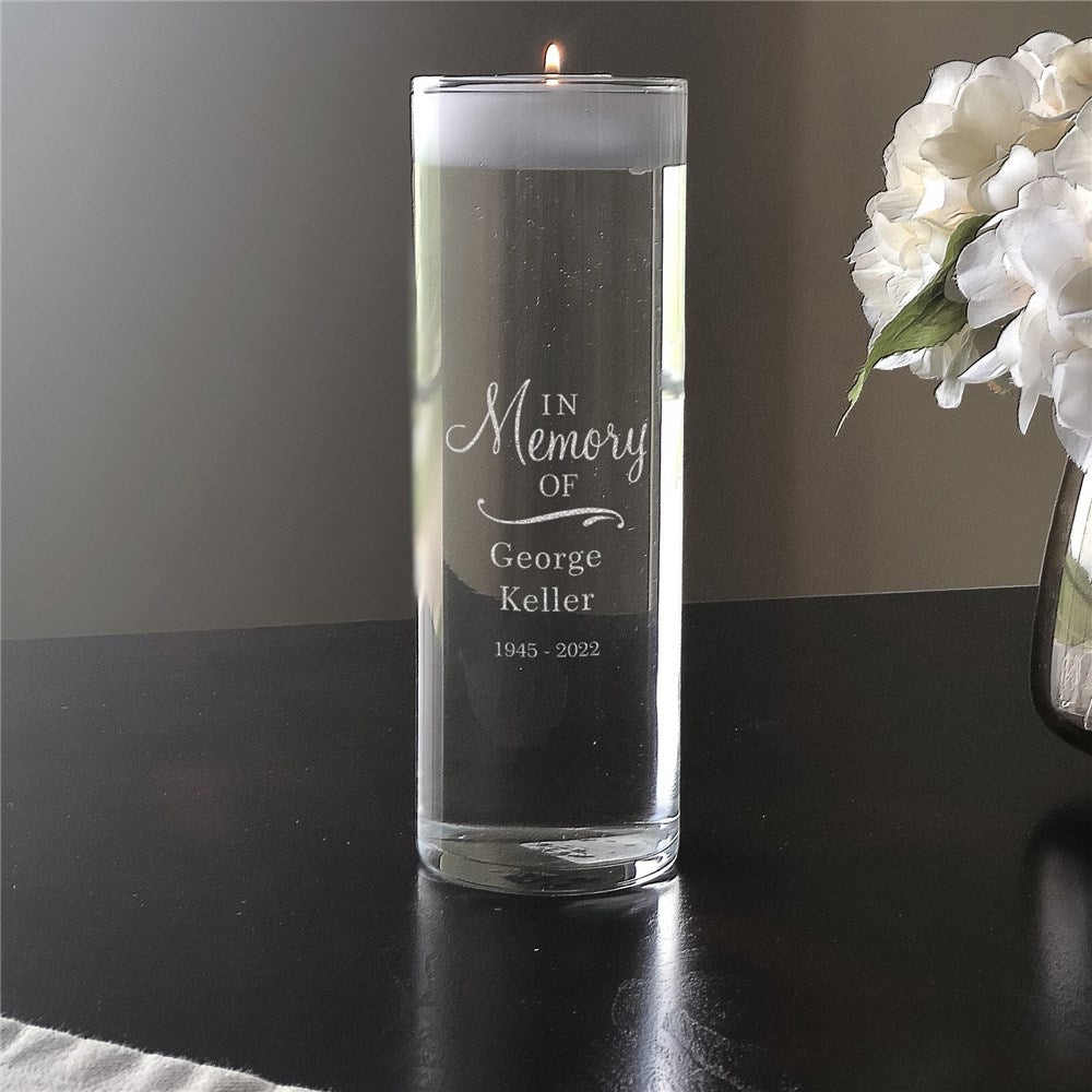 Glass memorial candle vase with engraved personalization and floating white votive candle for remembrance ceremonies.