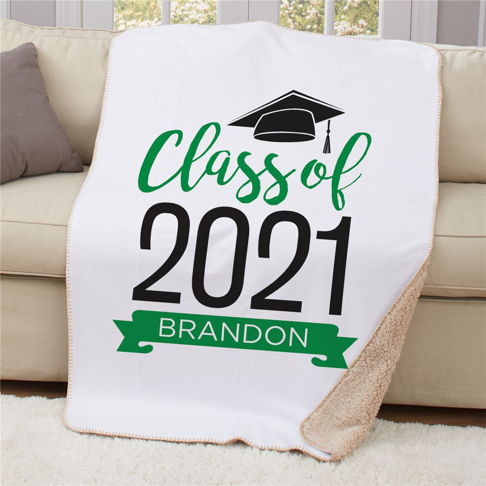 Personalized graduation Sherpa blanket in blue with a graduate cap and banner design, featuring a custom name and year.