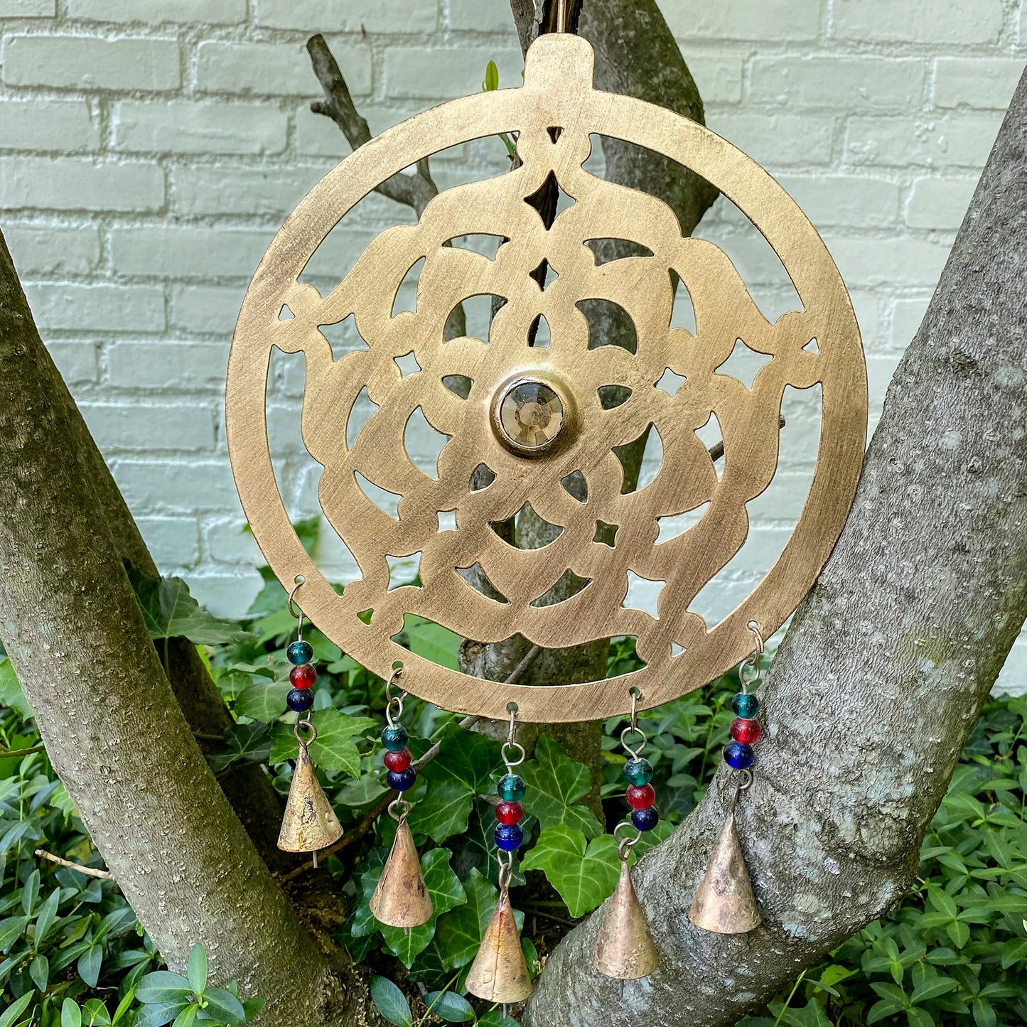 Fair Trade rustic metal chime with intricate cut-out design and brass-plated finish.