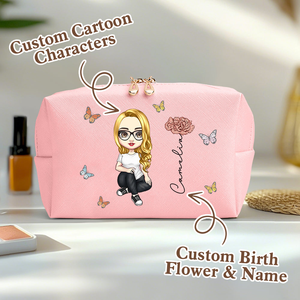 A pink personalized makeup bag on a table, featuring a custom cartoon character, birth flower, and name, with an overlay saying custom cartoon characters and custom birth flower and name.