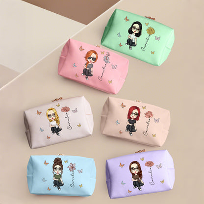 A display of six different colors of a personalized makeup bag, each featuring a customer-generated graphic. The design includes a custom avatar, birth flower, and name, showcasing the personalization options available for each bag.