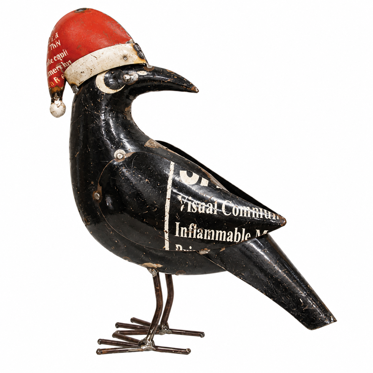 A vintage black metal bird figurine, likely a crow or raven, wearing a red Santa hat with white trim. The bird has a glossy black finish with some age-related wear and peeling paint, and white printed text is visible on its body.