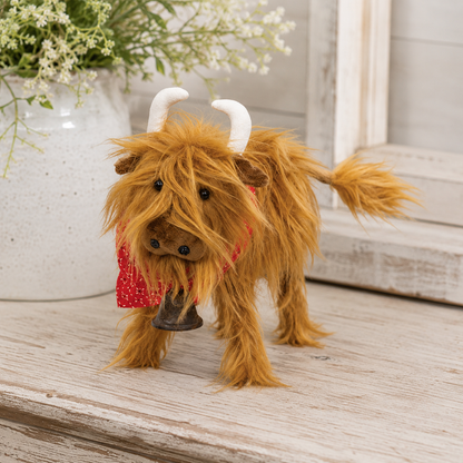 Brown fluffy Highland cow plush décor with shaggy fur, white horns, red bandana, rustic bell, and wooden legs for farmhouse, country, rustic, and cottage home décor.