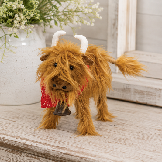 Brown fluffy Highland cow plush décor with shaggy fur, white horns, red bandana, rustic bell, and wooden legs for farmhouse, country, rustic, and cottage home décor.
