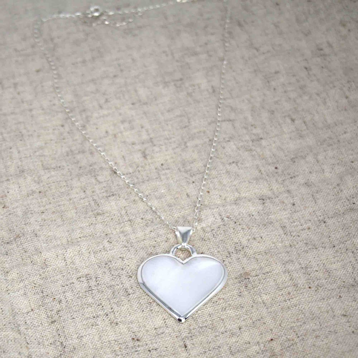 Artisan-made silver pendant in the shape of a heart with adjustable chain
