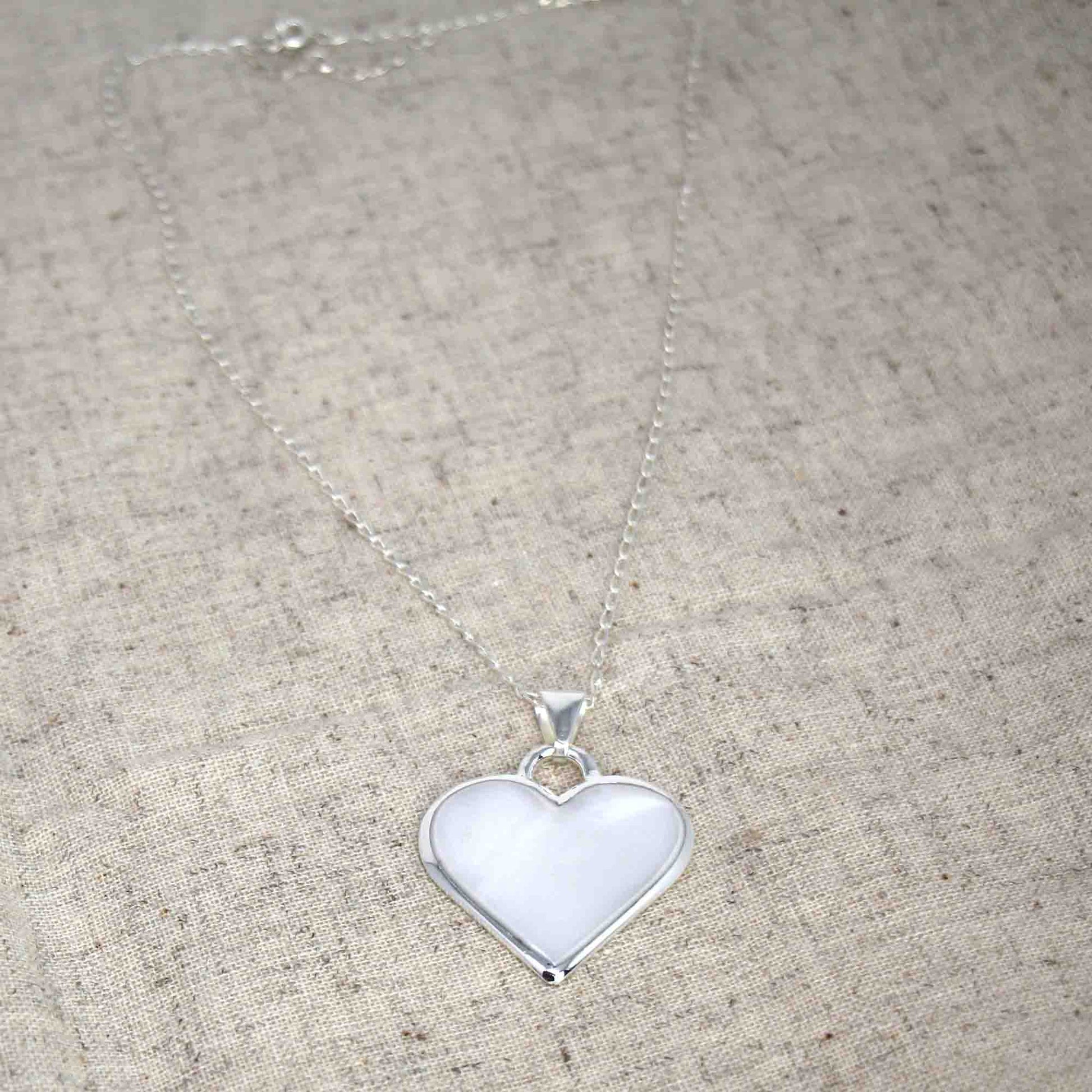 Artisan-made silver pendant in the shape of a heart with adjustable chain