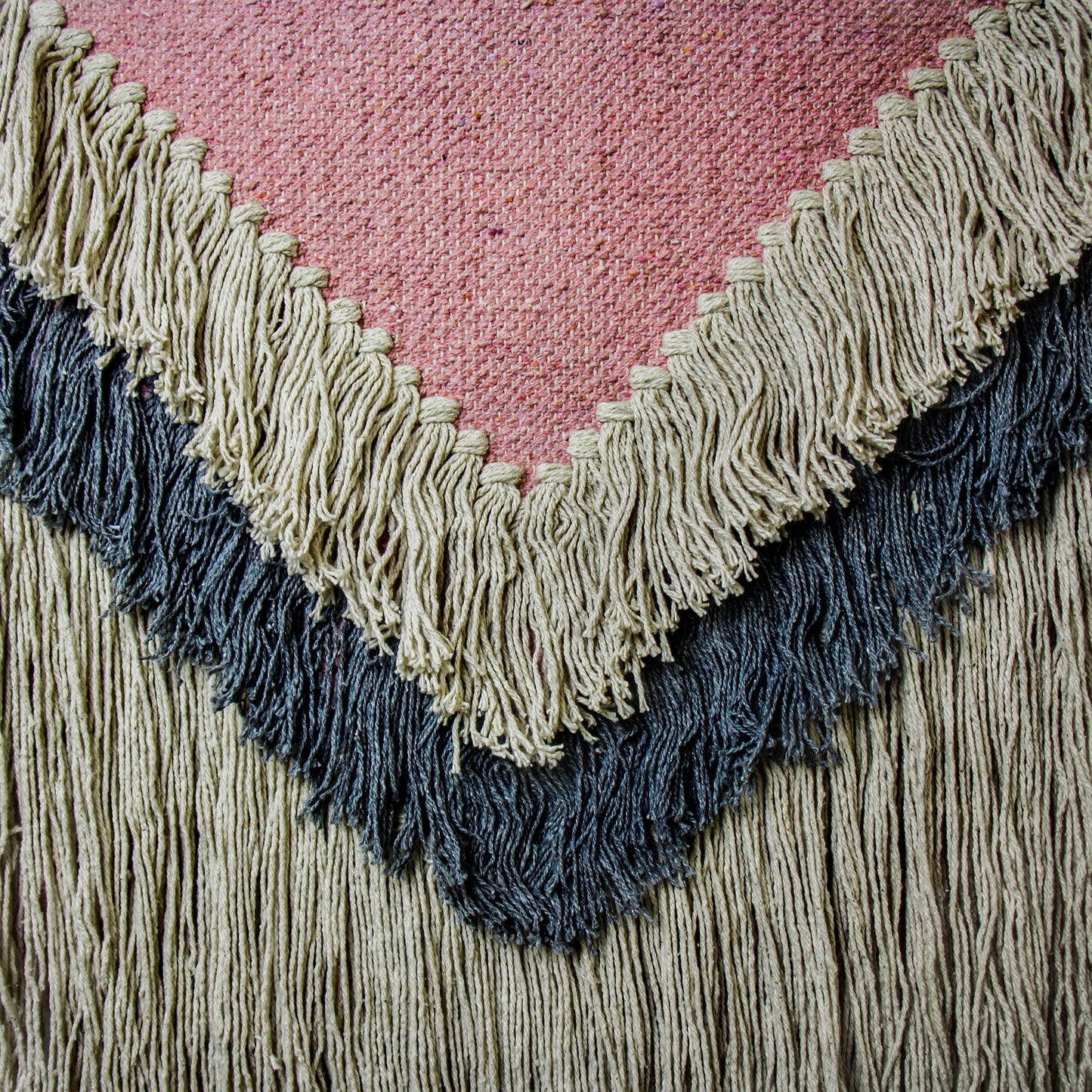 Close-up of artisan-woven textile wall hanging with soft texture and sustainable materials.