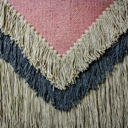 Close-up of artisan-woven textile wall hanging with soft texture and sustainable materials.