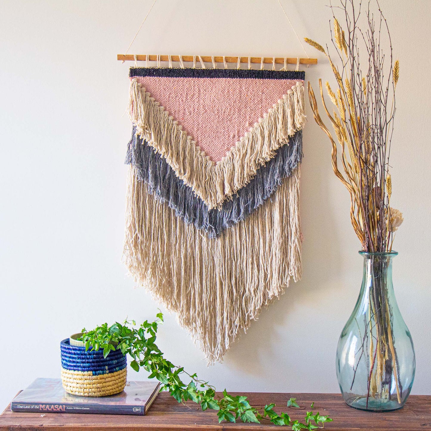 Eco-friendly cotton wall tapestry featuring a blend of soft pink, cream, grey, and charcoal hues.