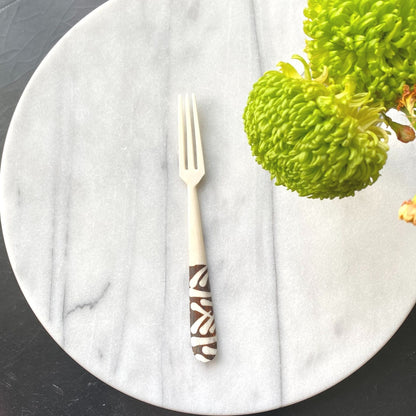 Unique bone appetizer forks displayed alongside cheese and fruit platter
