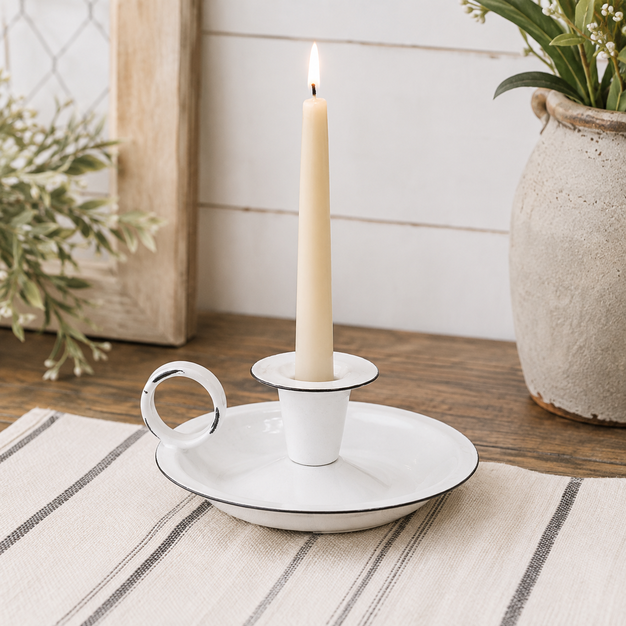 White enamel taper candle plate with a lightly distressed finish, raised candle cup, and small ring handle.
