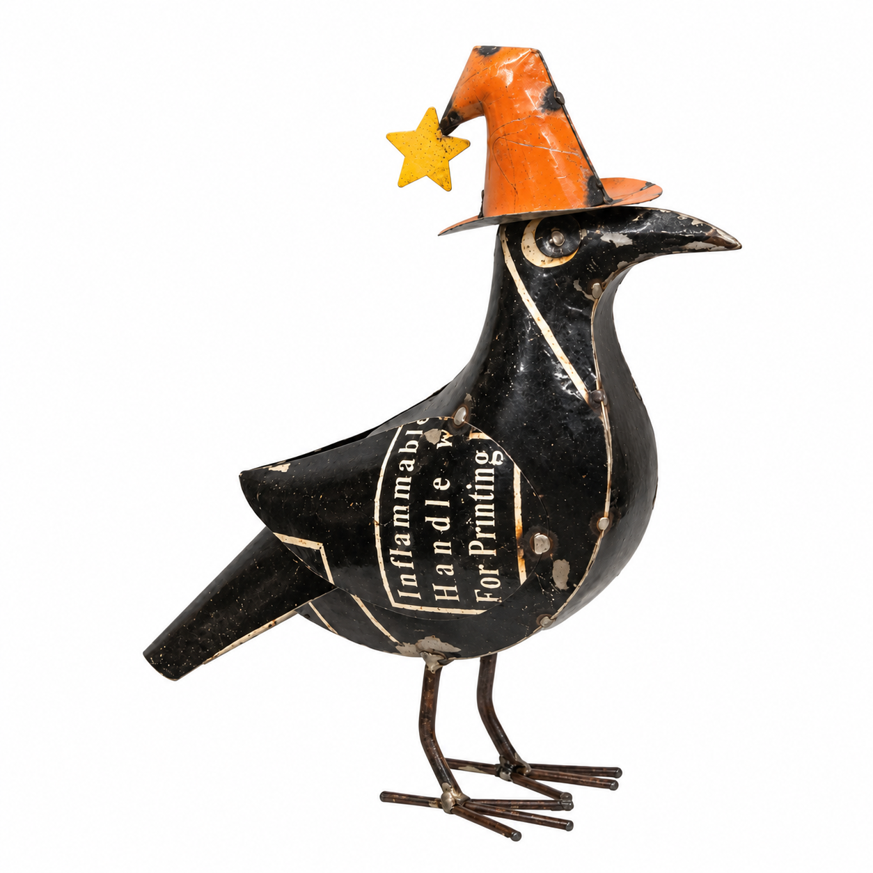 A decorative metal bird figurine in black with vintage-style printed text, wearing an orange witch hat with a small yellow star, photographed on a plain white background.