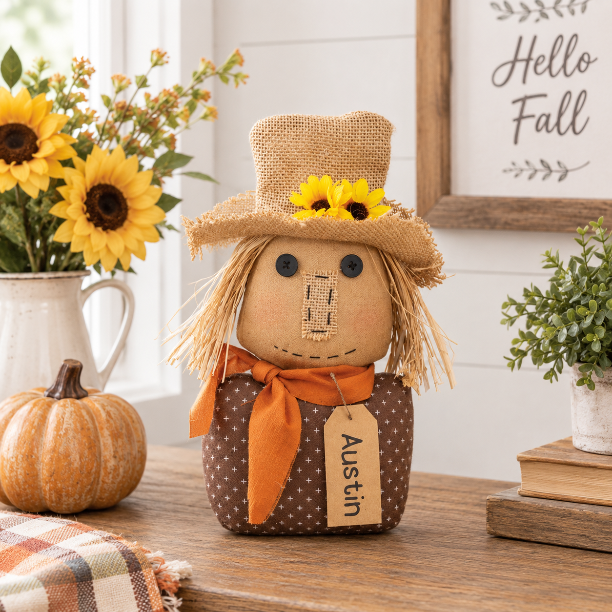 Austin stuffed scarecrow sitter with burlap hat, sunflower accents, burnt orange scarf, straw hair, and brown patterned shirt.