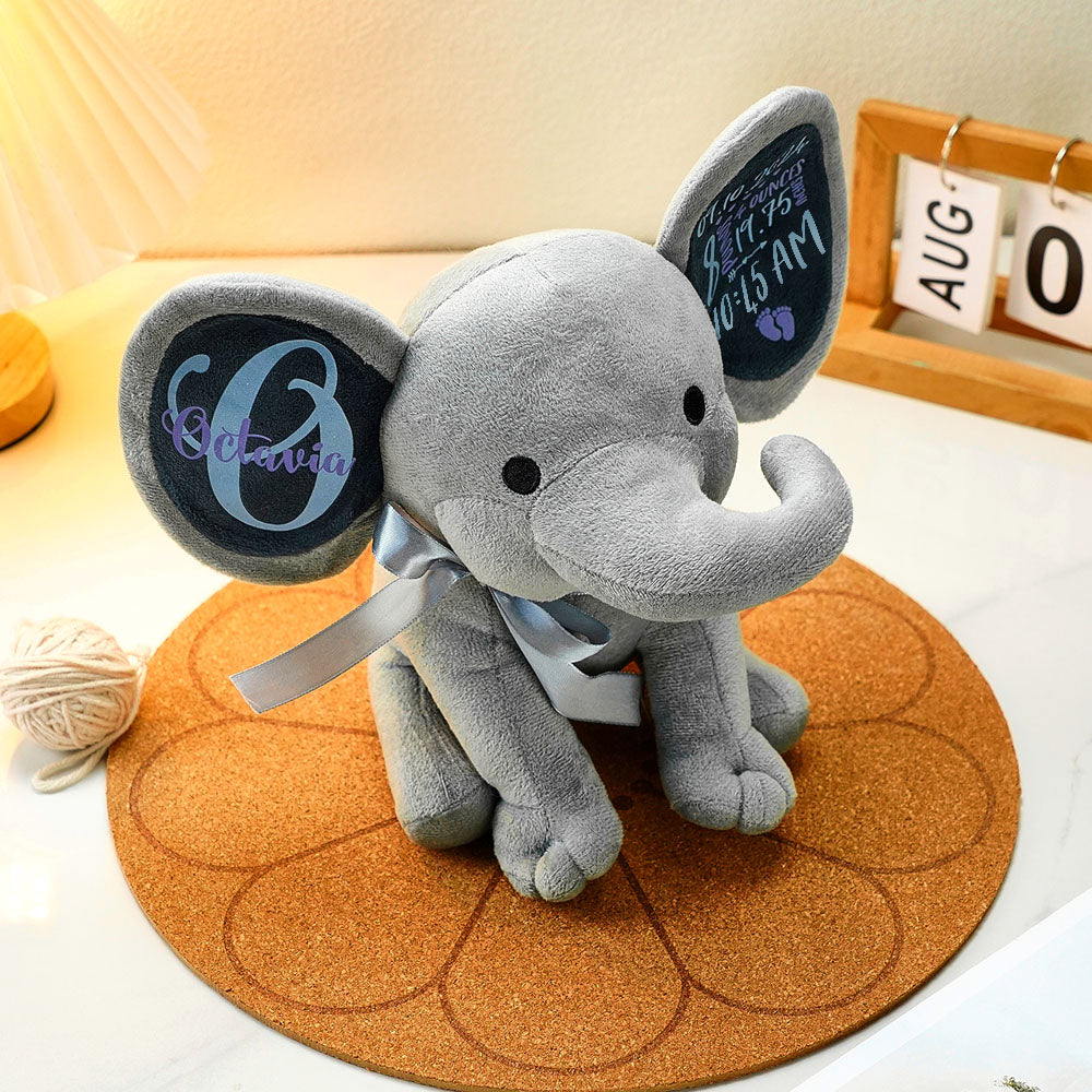 A stuffed elephant sitting on a table, showcasing its soft texture and personalized name and custom text.