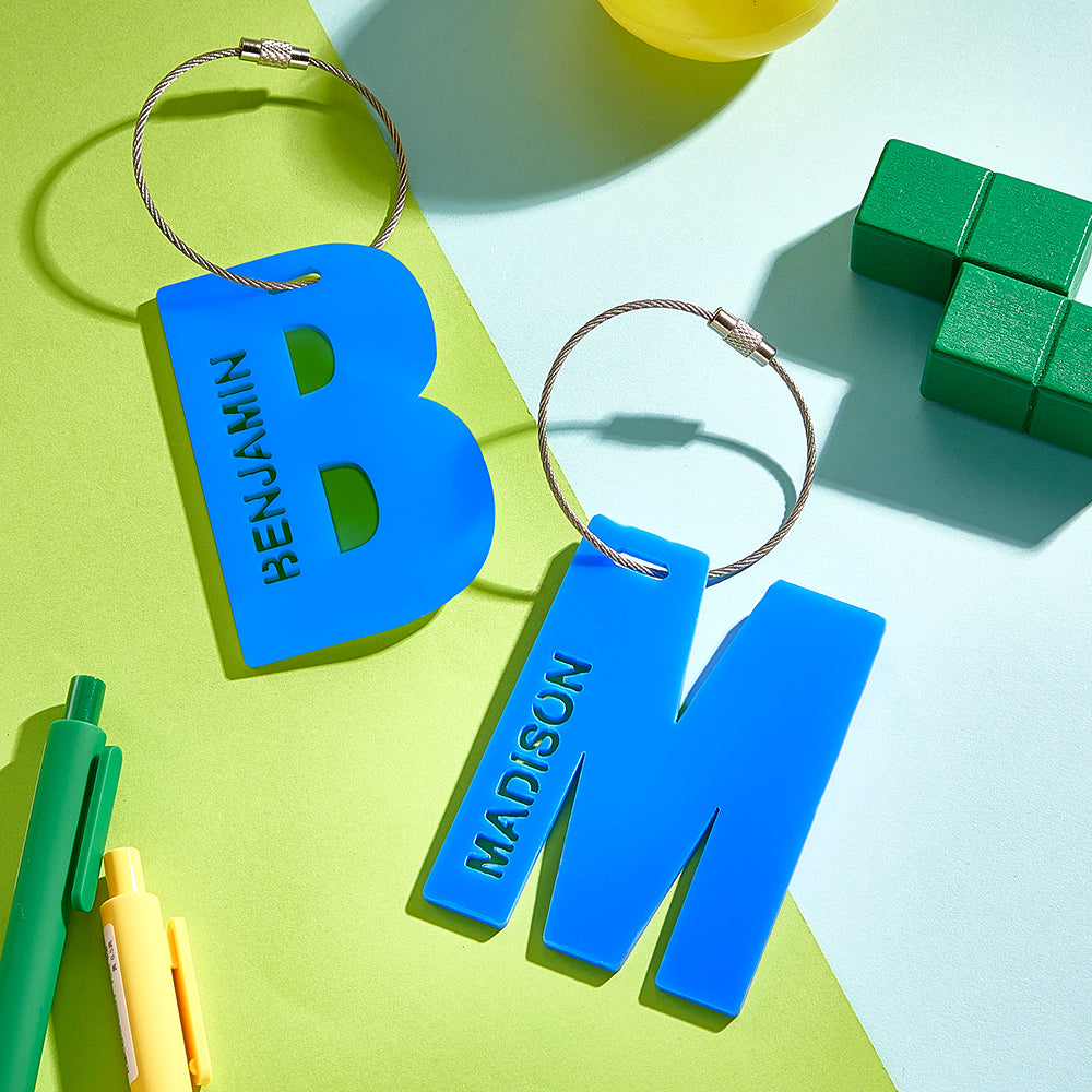 A close-up of the letter B and M in blue, showcasing their 3D printed design.