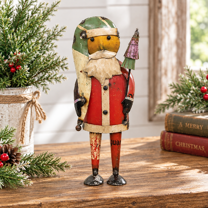 A rustic painted nutcracker figurine stands on a wooden table in a holiday setting, with evergreen branches, pinecones, and stacked Christmas books in the background.