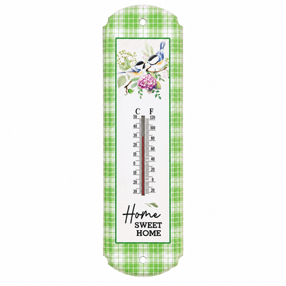 A vertical wall thermometer with a green and white plaid border, featuring a central white panel decorated with bluebirds, pink flowers, and a Celsius-Fahrenheit temperature scale. The bottom reads 'Home Sweet Home' in script and serif fonts.