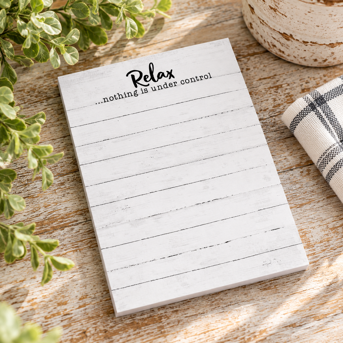 A white rustic notepad with horizontal woodgrain-style lines and the printed phrase 'Relax .