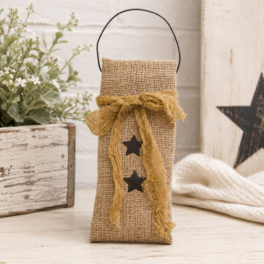 Primitive burlap hanging bag with black star design, tea-dyed cheesecloth ribbon, and black wire hanger for rustic farmhouse decor