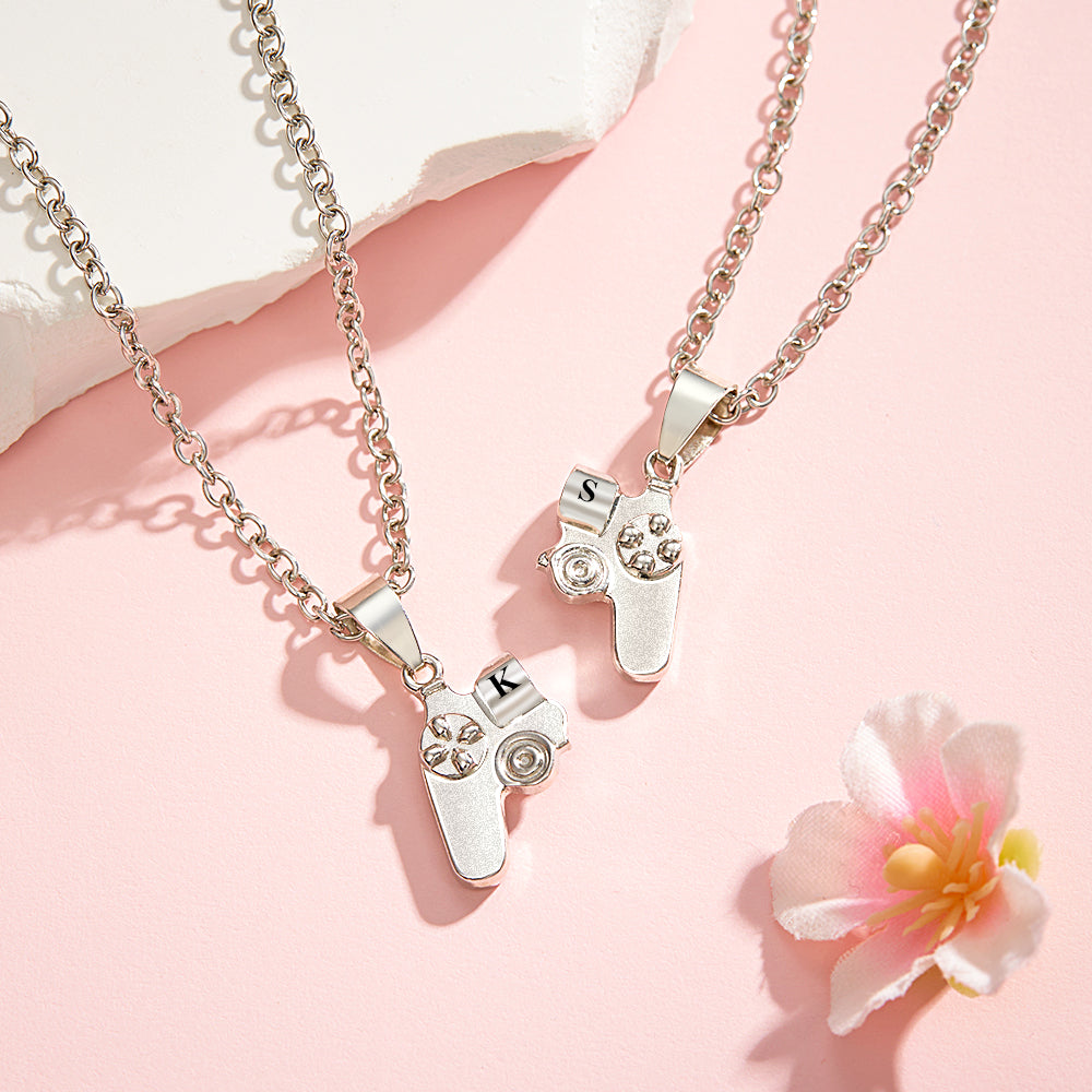 Romantic gamer couple jewelry, showcasing a close-up of the detailed engraved initials and magnetic feature of the pendant set.