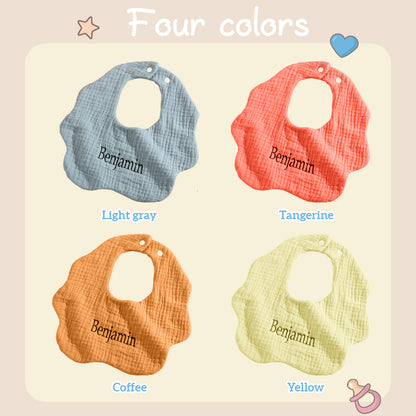 Four personalized baby bibs in blue, yellow, orange, and brown, each with custom embroidery options. Perfect for a unique gift for newborns or baby showers.