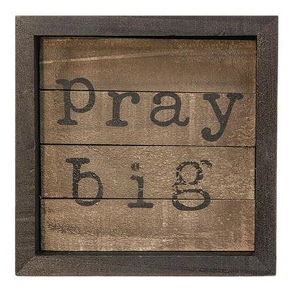 Small wooden slatted sign with dark frame and bold black lettering reading "pray big"
