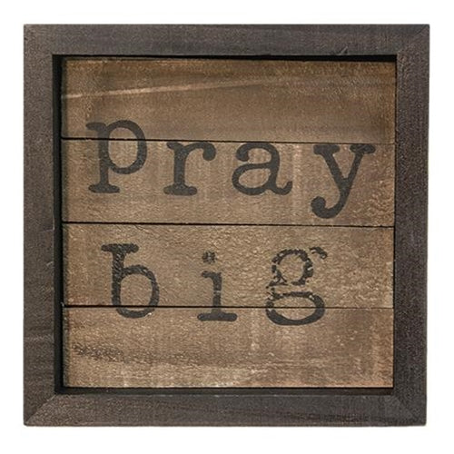 Small wooden slatted sign with dark frame and bold black lettering reading "pray big"