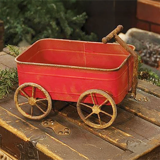 Rustic red metal wagon with wheels and pull handle, perfect for farmhouse decor or seasonal display.
